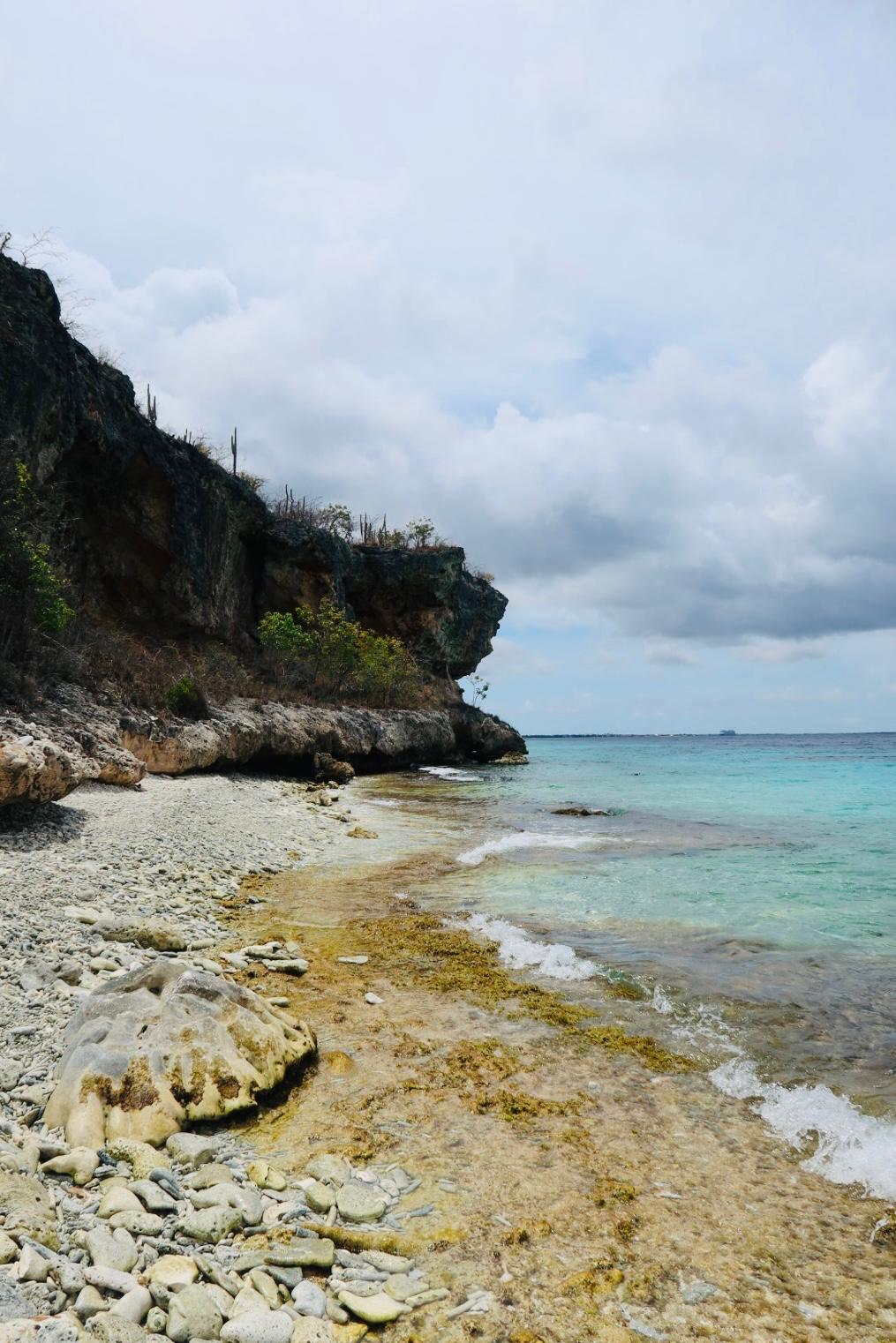 De baai onder de kalksteenkliffen, met het ondiepe rifdak vlak onder de kant